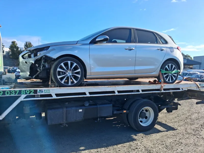 A silver Hyundai i30 with front-end damage on the tilt tray